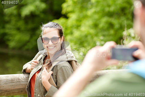 Image of couple with backpacks taking picture by smartphone