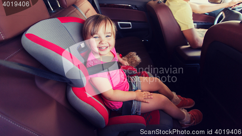 Image of happy child sitting in car seat and father driving