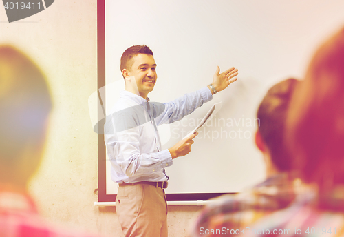 Image of group of students and smiling teacher with notepad