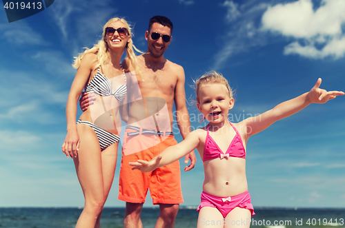 Image of close up of happy family with child on beach