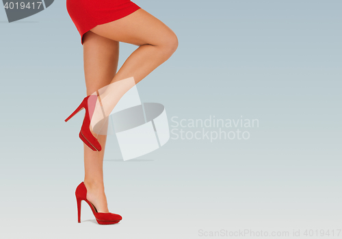 Image of close up of woman legs in red high heeled shoes