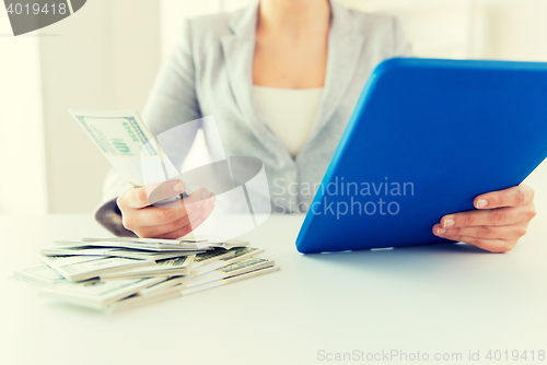 Image of close up of woman hands with tablet pc and money