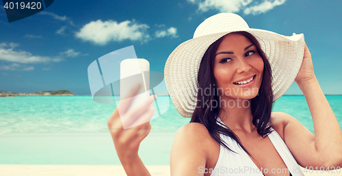 Image of young woman taking selfie with smartphone