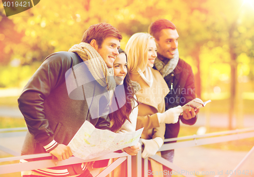 Image of couples with tourist map in autumn park