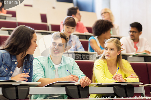 Image of group of students with notebooks in lecture hall