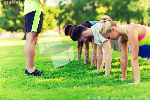 Image of group of friends or sportsmen exercising outdoors