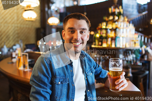 Image of happy man drinking beer at bar or pub