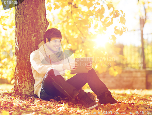 Image of man with tablet pc in autumn park