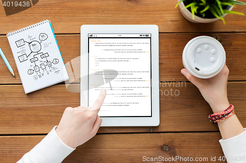 Image of close up of woman with tablet pc on wooden table