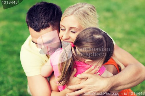 Image of happy family hugging outdoors