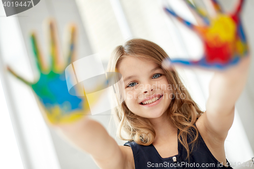 Image of happy girl showing painted hand palms at home