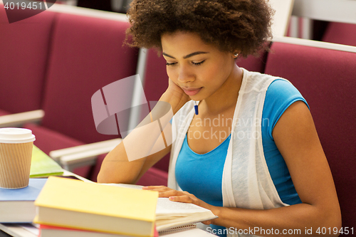 Image of student girl with books and coffee on lecture