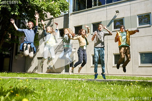 Image of happy teenage students or friends jumping outdoors