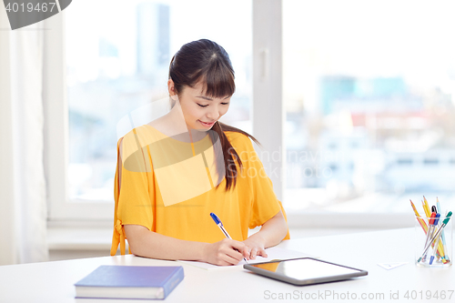 Image of happy asian woman student with tablet pc at home