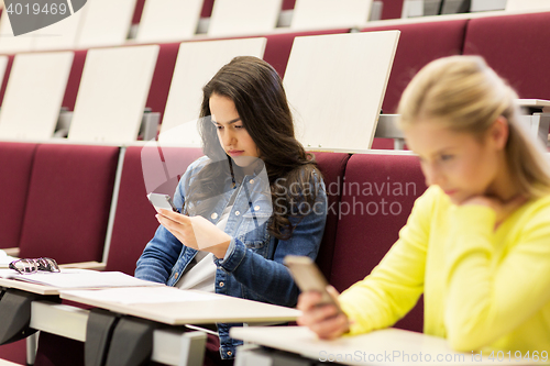 Image of student girls with smartphones on lecture