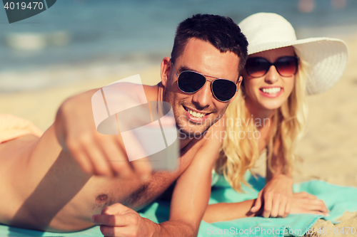 Image of happy couple in swimwear walking on summer beach