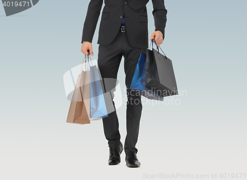 Image of close up of man in suit with shopping bags