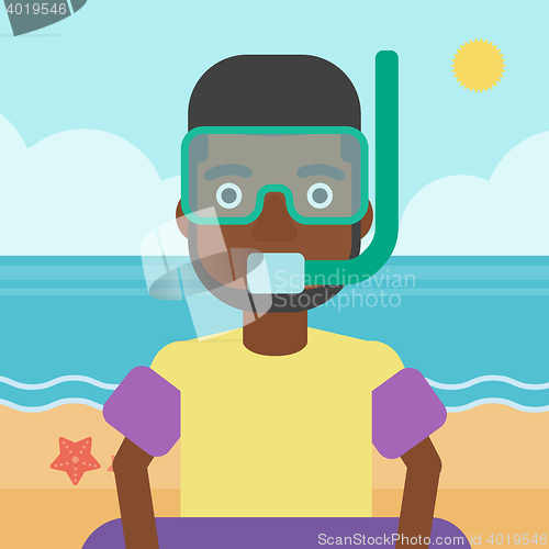 Image of Man with snorkeling equipment on the beach.