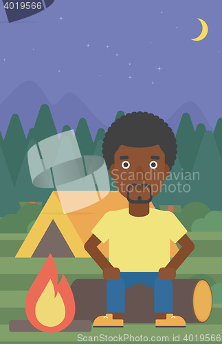 Image of Man sitting on log in the camping.