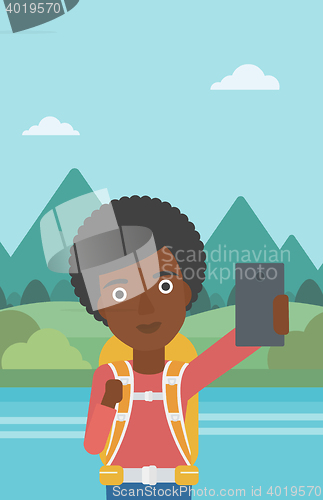Image of Woman with backpack making selfie.