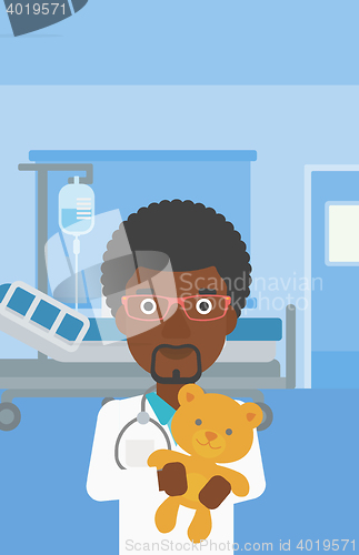 Image of Pediatrician doctor holding teddy bear.
