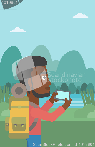 Image of Man with backpack taking photo.