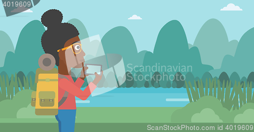 Image of Woman with backpack taking photo.