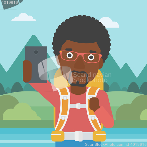 Image of Man with backpack making selfie.