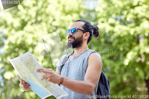 Image of man traveling with backpack and map in city