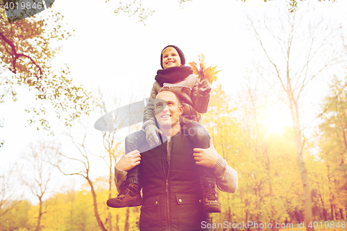 Image of happy family having fun in autumn park