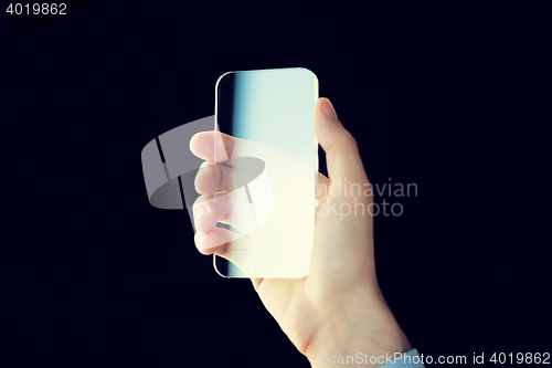 Image of close up of male hand with transparent smartphone