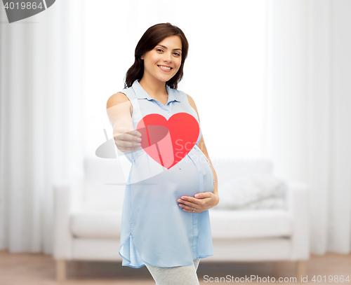 Image of happy pregnant woman with red heart touching belly