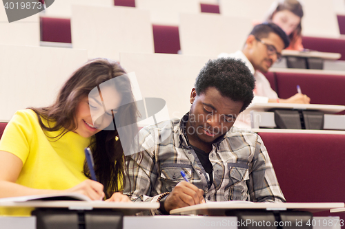 Image of group of students with notebooks in lecture hall