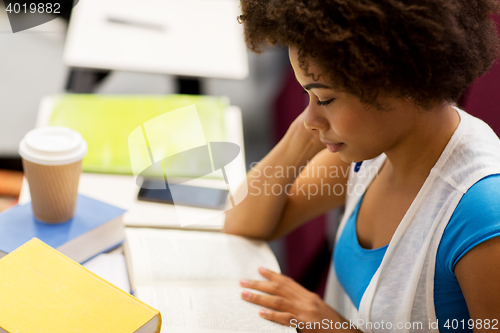 Image of student girl with books and coffee on lecture