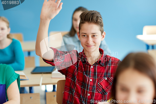 Image of happy student boy raising hand at school lesson