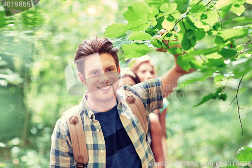 Image of group of smiling friends with backpacks hiking