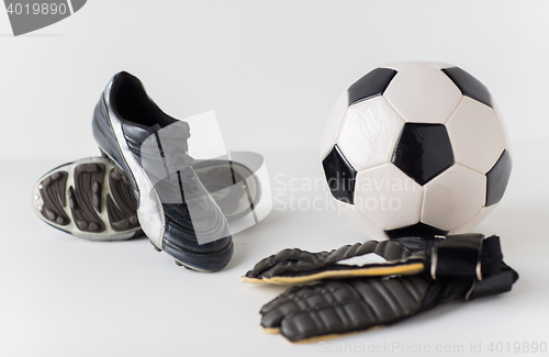 Image of close up of goalkeeper gloves, ball, soccer boots