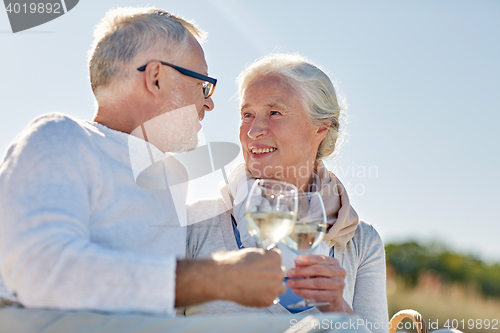 Image of happy senior couple having picnic on summer beach