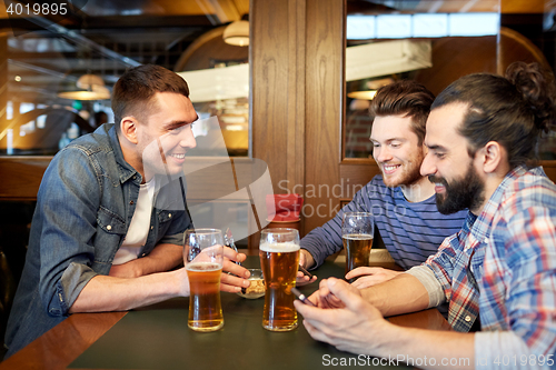 Image of men with smartphones drinking beer at bar or pub