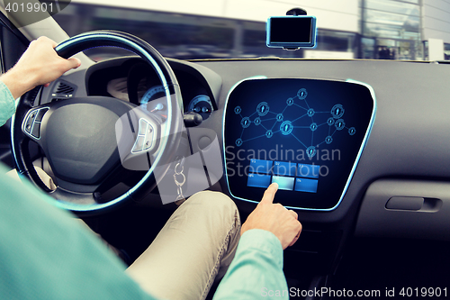 Image of close up of man driving car with on board computer
