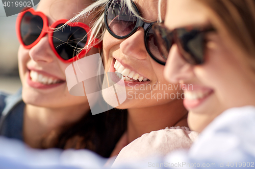 Image of group of smiling women taking selfie on beach