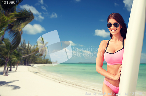 Image of smiling young woman with surfboard on beach