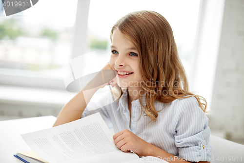 Image of happy student girl reading book at school