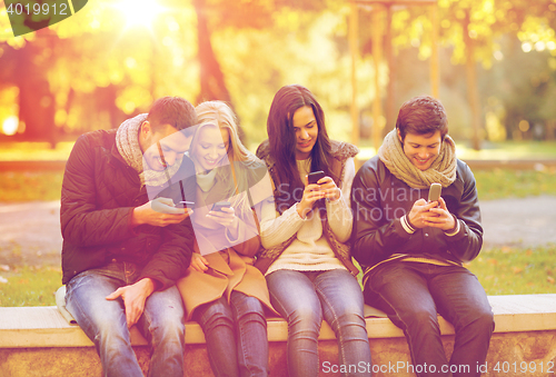 Image of group of friends having fun in autumn park