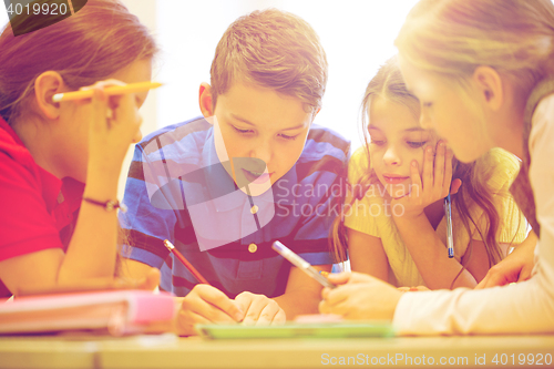 Image of group of students talking and writing at school