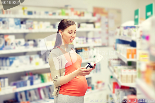 Image of happy pregnant woman with medication at pharmacy