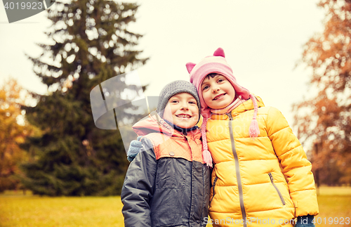 Image of happy little girl and boy in autumn park