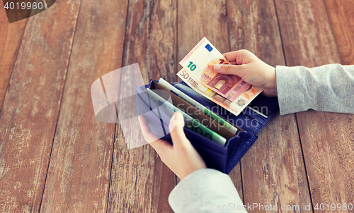 Image of close up of woman hands with wallet and euro money
