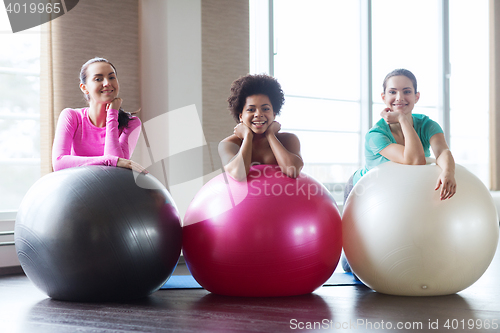 Image of group of smiling women with exercise balls in gym