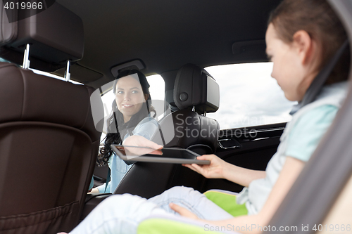 Image of happy family with tablet pc driving in car